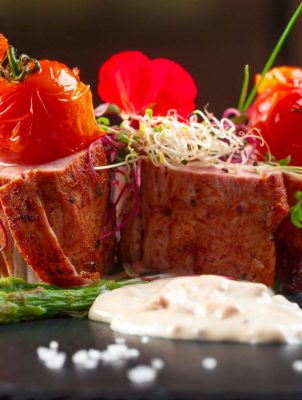 veal-medallions-with-asparagus-on-black-dishware-2025-02-25-01-07-32-utc.jpg